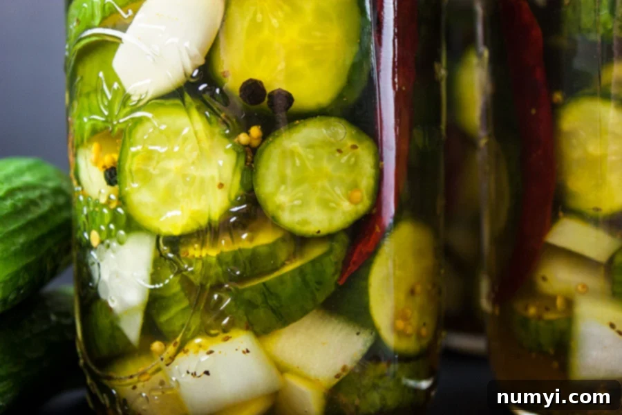 Freshly prepared pickles being packed into mason jars, ready for the brine.