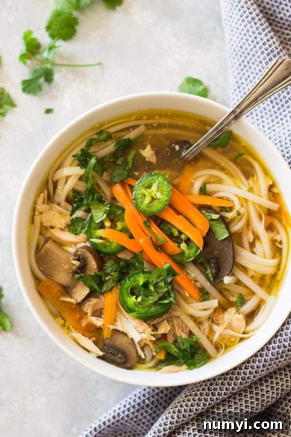 Close-up of Chinese chicken noodle soup in a bowl with chopsticks
