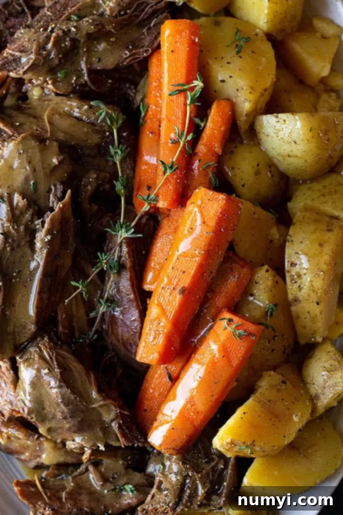 Melt-in-Your-Mouth Pot Roast 6 Close up of roast and veggies garnished with thyme.