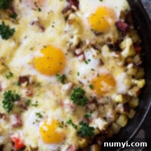 Small image of Cheesy Corned Beef Hash with Baked Eggs in a skillet