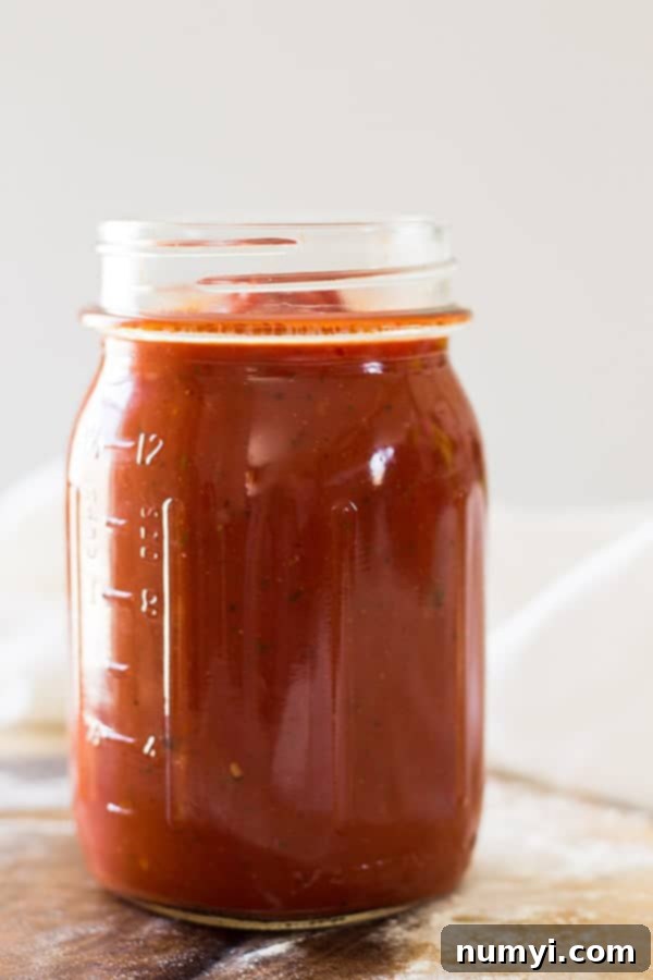 Freshly made homemade pizza sauce in a bowl, ready to be spread on pizza dough, highlighting its vibrant color and texture.