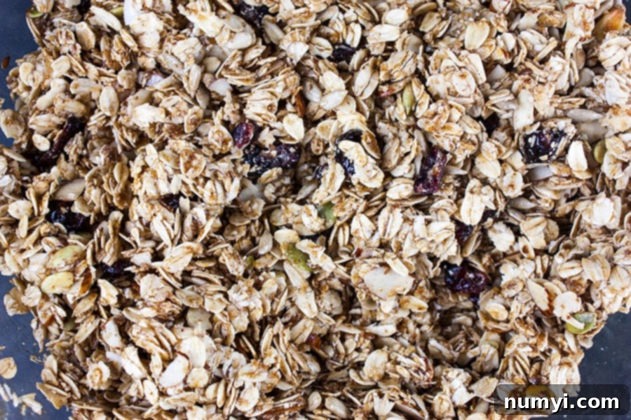 Granola bar ingredients mixed in a glass mixing bowl.