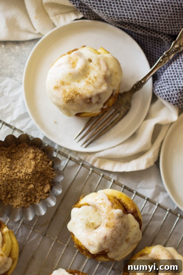 A close-up shot of an iced cinnamon roll muffin, ready to be enjoyed, with a bite taken out.