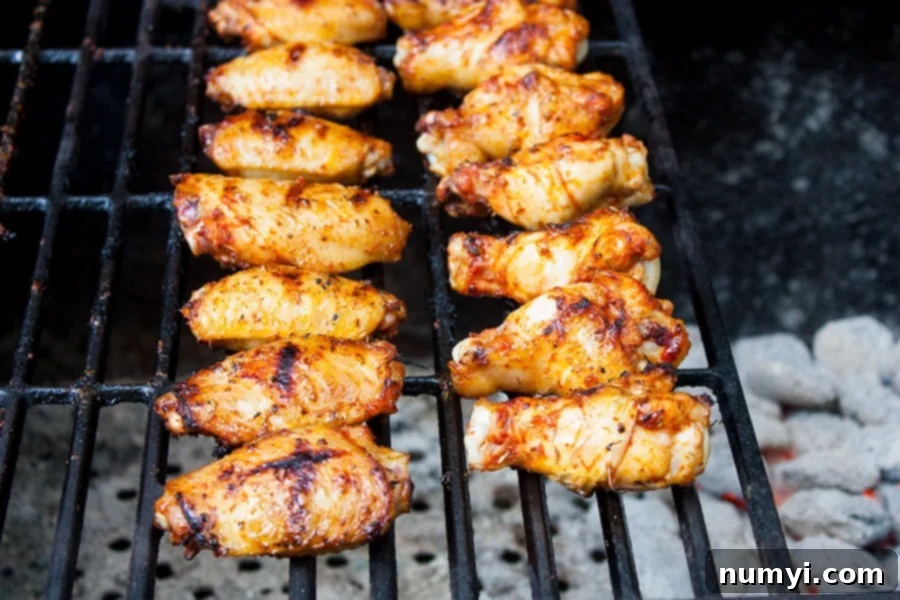 Cajun Smoked Wings - chicken wings sizzling on a hot grill with visible smoke.