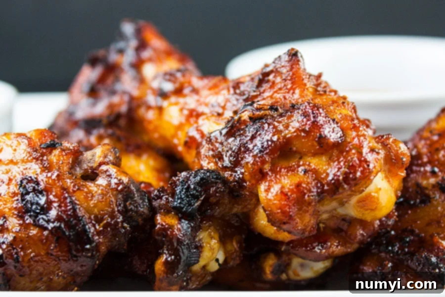 Cajun Smoked Wings - close-up of beautifully sauced and smoked wings on a white platter, ready to serve.