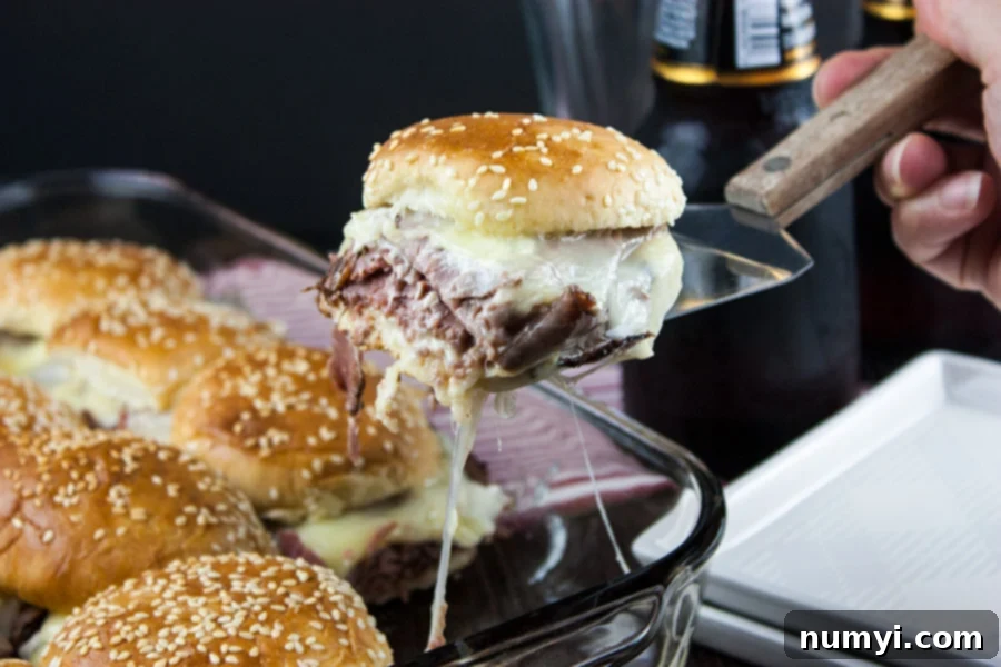 Smoky Roast Beef Sliders with Zingy Horseradish 8 Roast beef slider lifted out of the pan on a spatula.