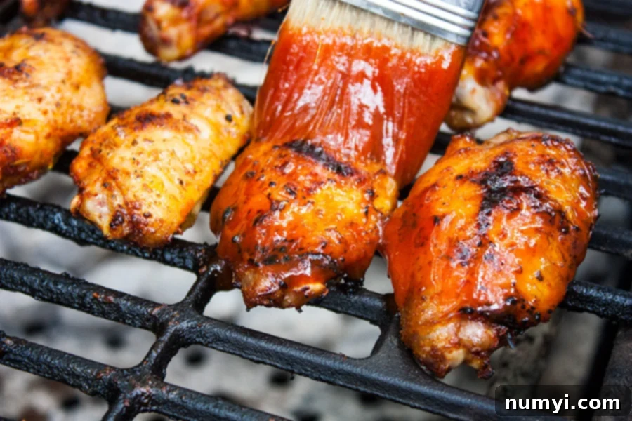 Cajun Smoked Wings being sauced on a grill, ready for game day.