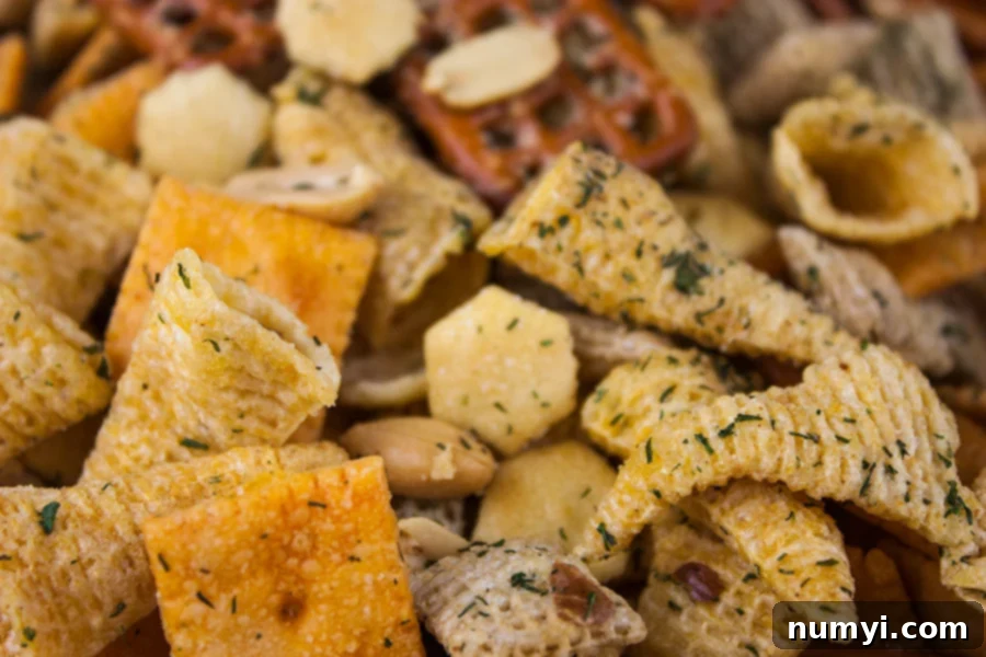 A close-up view of Ranch Party Mix, showing a delightful array of cheese crackers, crunchy Bugles, and delicate oyster crackers, all generously coated in savory spices.