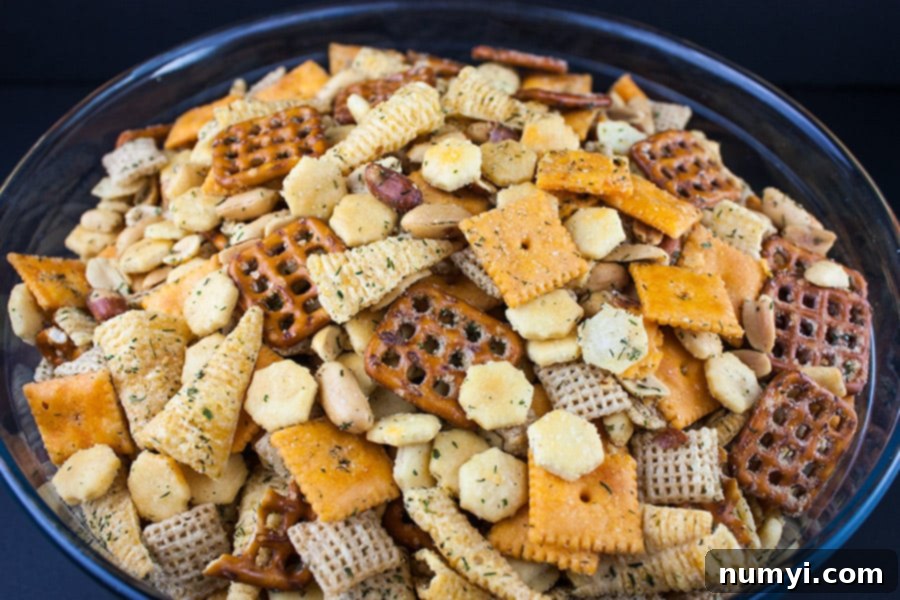Another close-up of Ranch Party Mix in a glass bowl, showcasing the rich golden color and varied textures of the spiced snack pieces.