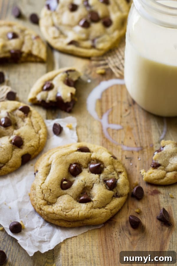 View of no chill soft chocolate chip cookies on wooden surface with milk