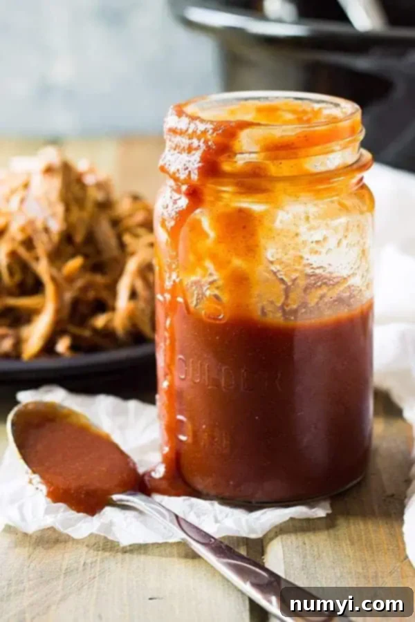 side view: texas BBQ sauce in a jar with a spoon