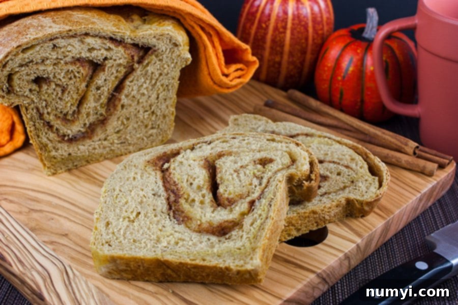 Thick slices of homemade Pumpkin Cinnamon Swirl Bread arranged on a rustic wooden cutting board, invitingly ready for serving.