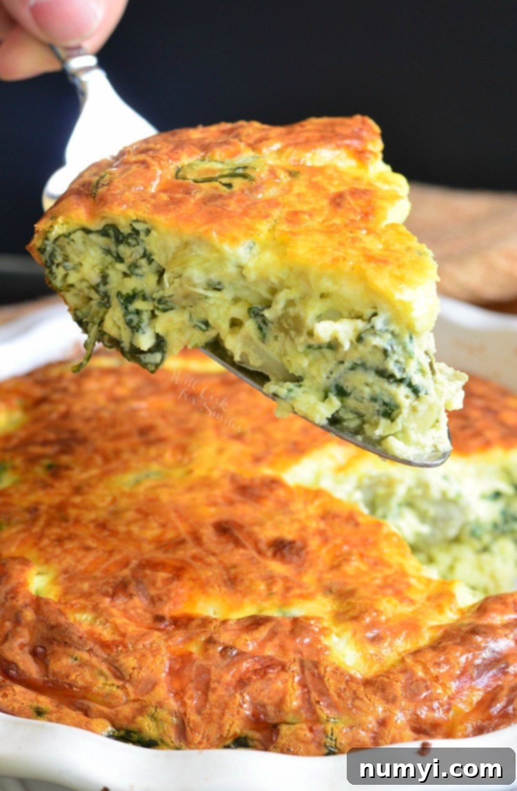 A savory Spinach Artichoke Crustless Quiche slice on a plate, showing its creamy texture.