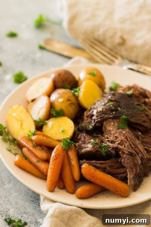 Crazy tender, melt in your mouth slow cooker pot roast with carrots and potatoes. This super easy meal requires little prep and the crockpot does all the work! | www.countrysidecravings.com