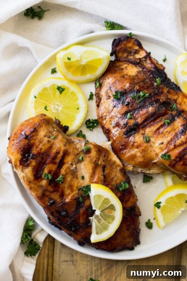 This Simple Marinade for Chicken is perfect for your summer time bbqs. It's easy to prepare and adds tons of flavor! Cooked chicken breasts are shown with a golden-brown crust.