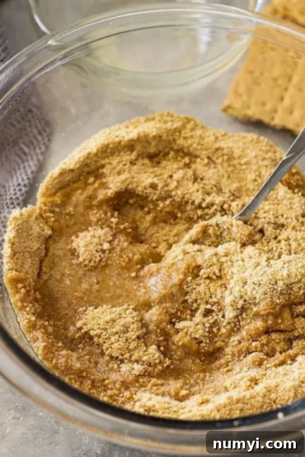 Perfect Homemade Graham Cracker Crust 6 overhead process shot: a silver fork mixing graham cracker pie crust recipe ingredients