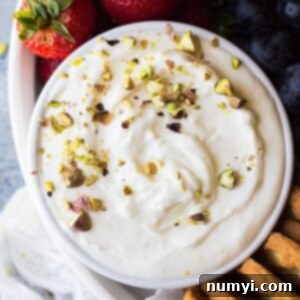 A top-down view of a creamy marshmallow fruit dip in a white bowl, ready to be served.