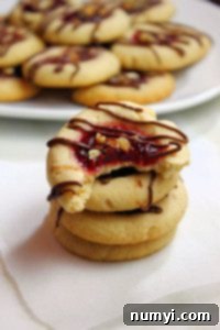 Freshly baked Raspberry Thumbprints cooling on a wire rack.