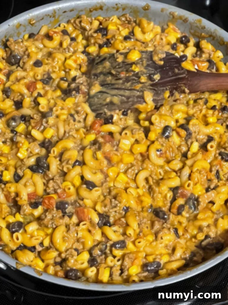 The finished creamy and cheesy one-pot taco pasta skillet on the stovetop, ready to be served.