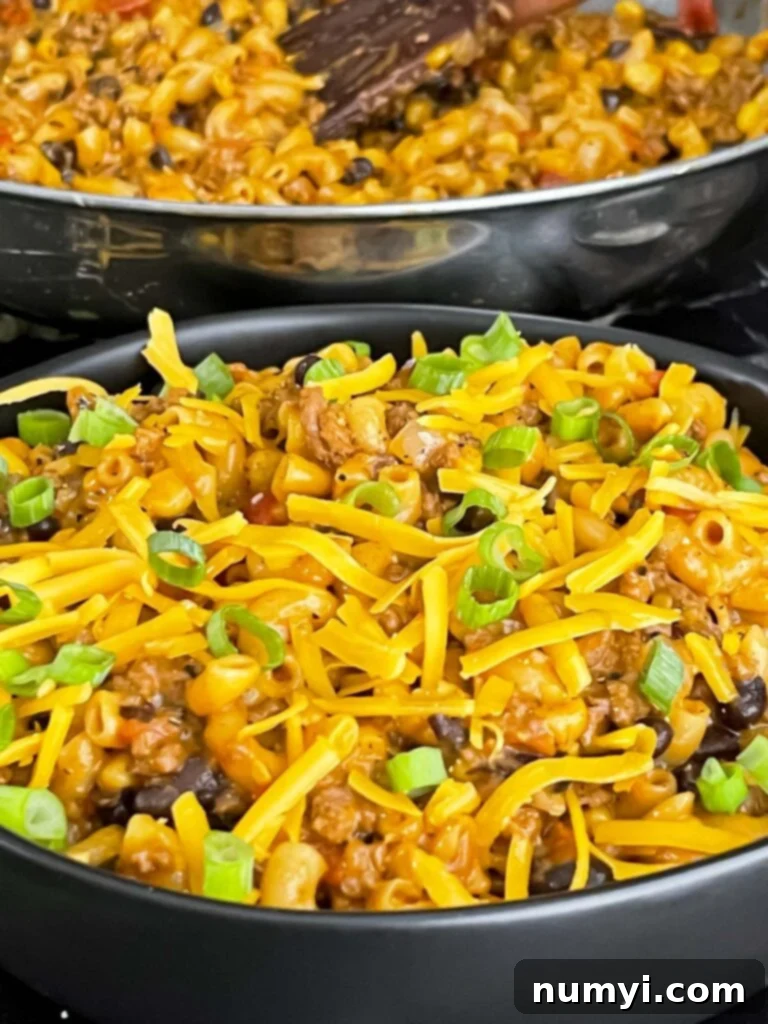 Another close-up of the appetizing one-pot taco pasta skillet in a dark bowl, garnished and ready.