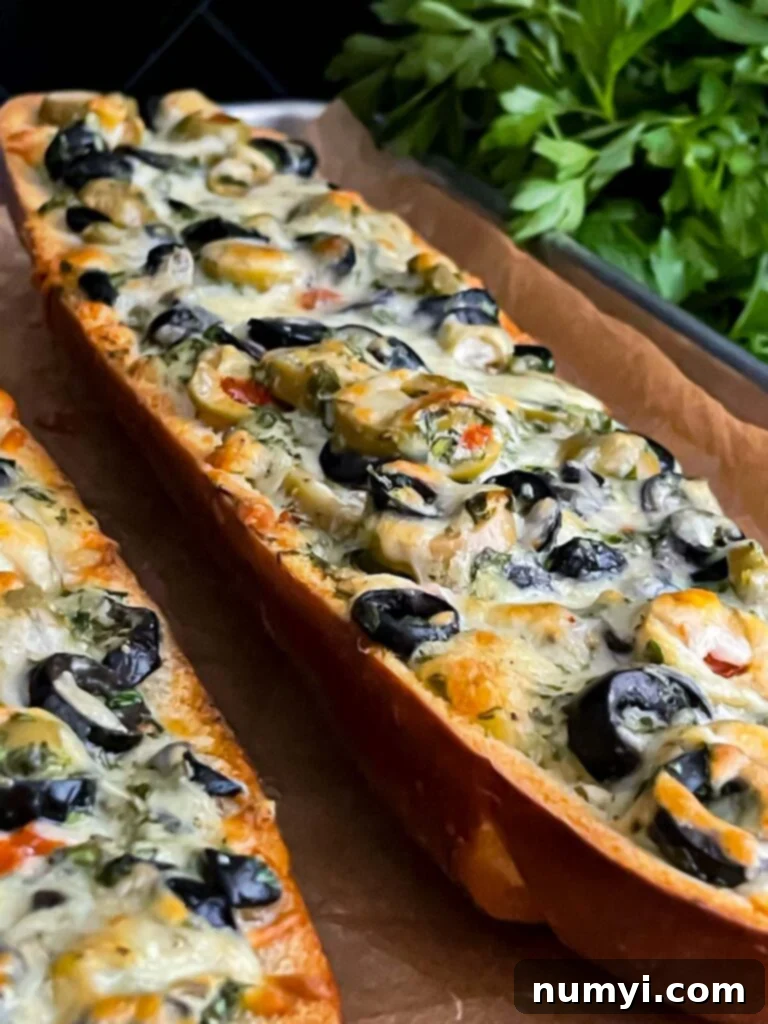 Olive cheese bread freshly baked on a parchment paper lined baking sheet, still hot and bubbly.