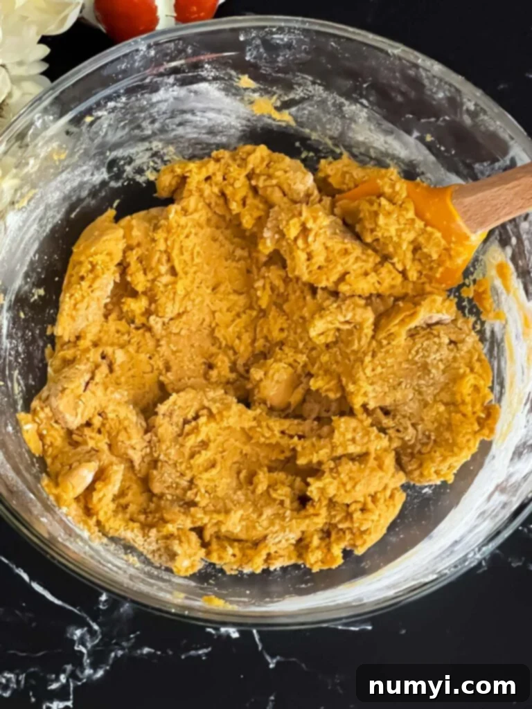 Pumpkin Snickerdoodles dough perfectly mixed and ready for shaping in a clear glass bowl, showing its uniform texture.