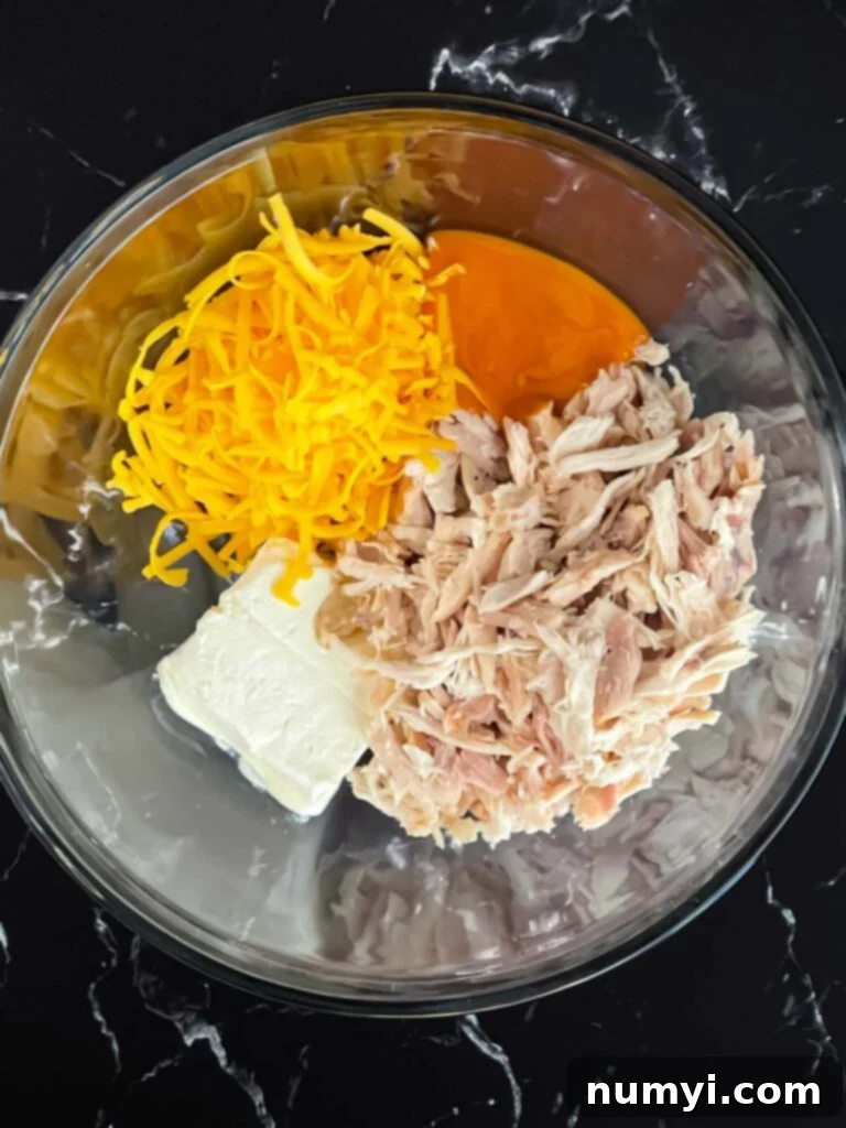 Ingredients for buffalo chicken wonton cups in a glass bowl.