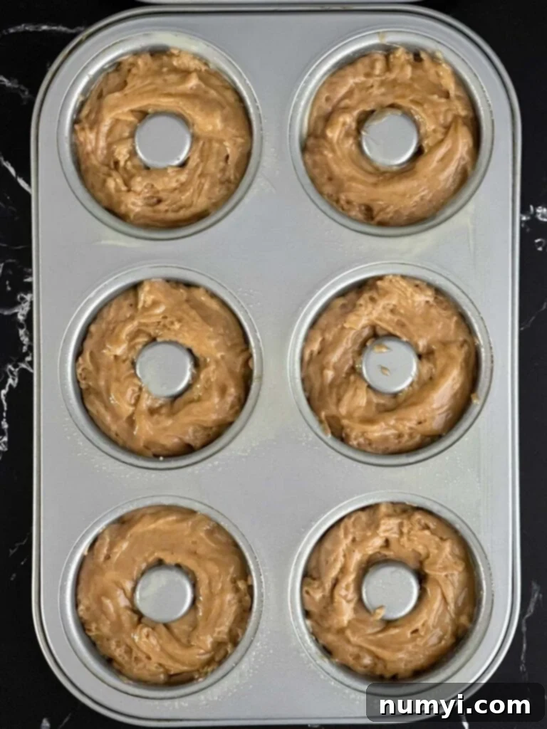 Spiced Apple Cider Baked Doughnuts 6 Baked apple cider donut batter divided into a six section donut pan.