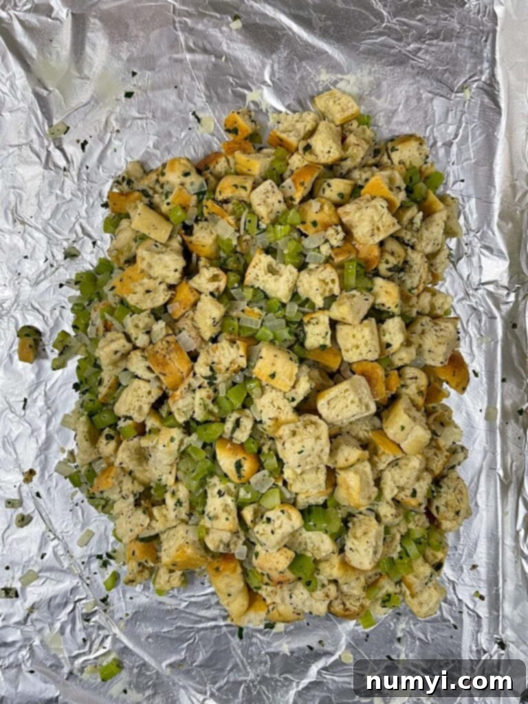 Stuffing expertly shaped into a tight square on a foil-lined baking sheet, forming a base for the turkey.
